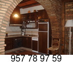 Cocina de línea rústica integrada en el salón